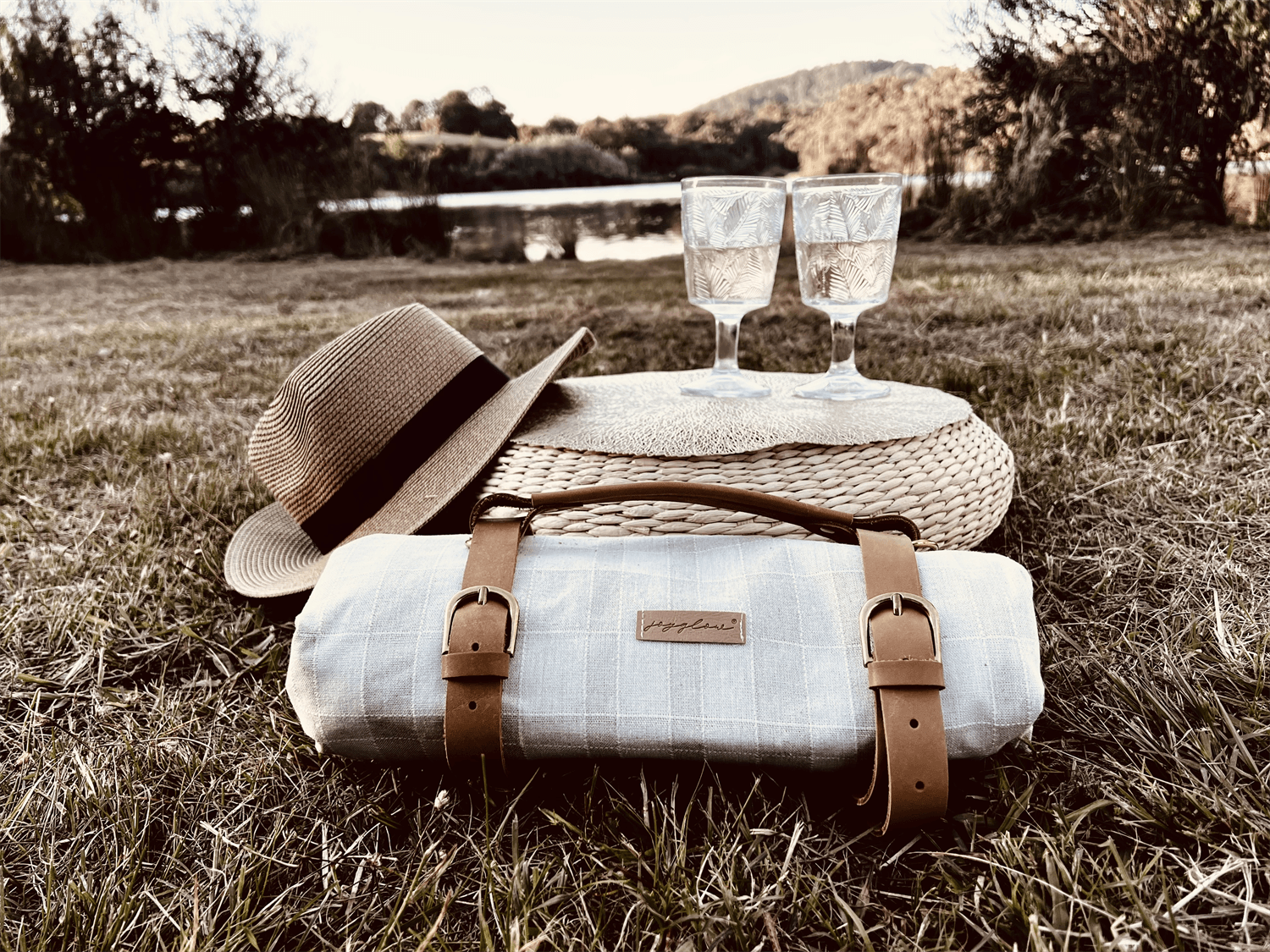 a hat, glasses, and a bag sitting in the grass